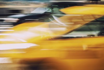 Blurred motion of yellow car on road