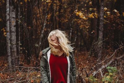 Woman standing against trees in forest