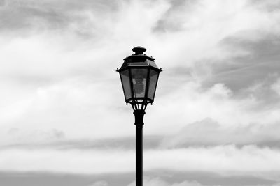 High section of lamp post against clouds
