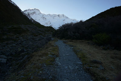 Road amidst mountains against clear sky