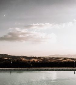 Scenic view of lake by trees against sky