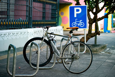 Bicycle sign on railing in city