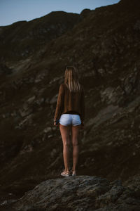 Rear view of woman standing on rock