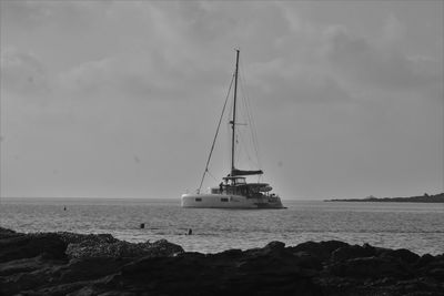Sailboat sailing on sea against sky