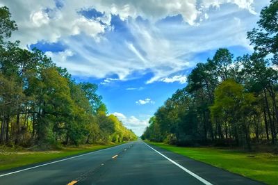 Road amidst trees against sky