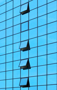 Low angle view of modern building against blue sky