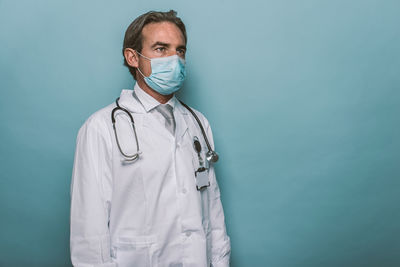 Doctor wearing mask against blue background