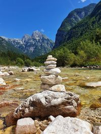 Stack of rocks by mountain against sky