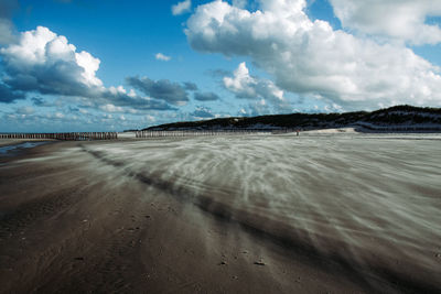 Road leading towards beach against sky