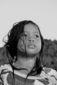 Portrait of girl with arms raised against sky