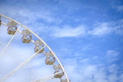 Low angle view of ferris wheel against blue sky