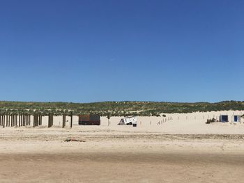 Scenic view of beach against clear blue sky