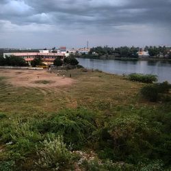 View of calm lake against cloudy sky