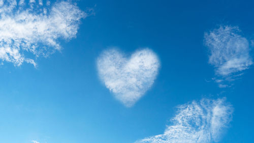 Low angle view of heart shape against blue sky