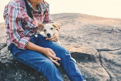 Woman with dog sitting outdoors