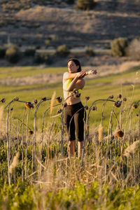 Full length of woman with exercising on field