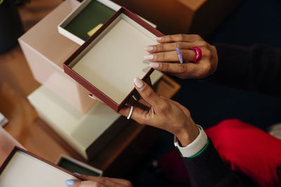 Hands of female entrepreneur holding box lid at office