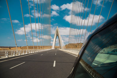 View of suspension bridge against cloudy sky