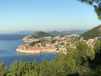 Scenic view of sea and mountains against clear blue sky