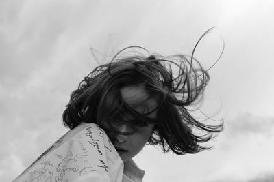 Portrait of young woman against sky