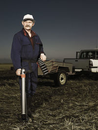 Portrait of man standing on field against sky