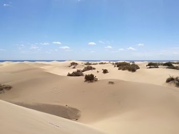 Scenic view of sand dunes against sky