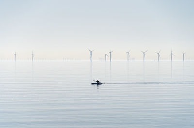 Offshore wind turbines generating renewable electricity and energy  atmospheric background image