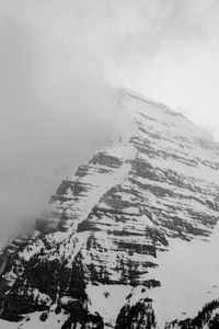 Low angle view of snow covered mountain against sky