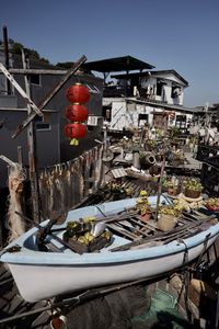 Boats moored in canal by city against sky