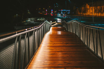 Illuminated footbridge in city at night