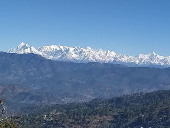 Scenic view of snowcapped mountains against clear blue sky