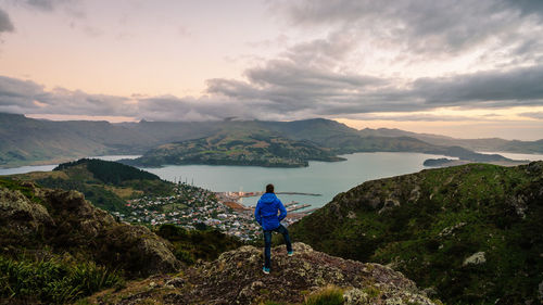 Rear view of man standing on mountain against sky