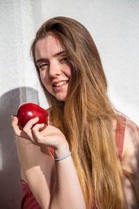Portrait of young woman holding apple