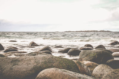 Rocks on beach against sky