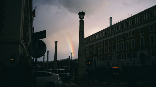 Street amidst buildings against sky at dusk