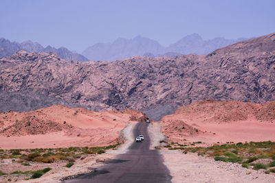 Road leading towards mountains against sky