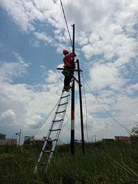 Low angle view of traditional windmill on field against sky