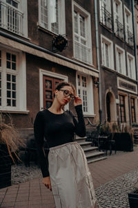 Side view of young woman looking at camera