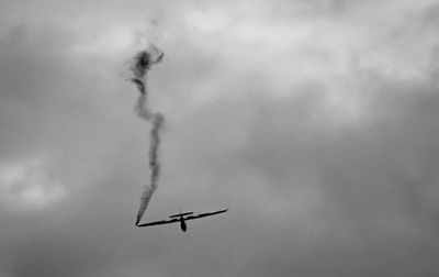 Low angle view of airplane flying against sky