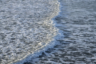 High angle view of waves rushing towards shore