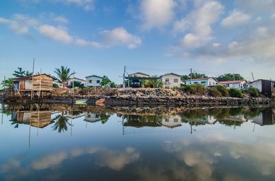 Reflection of buildings on lake against sky