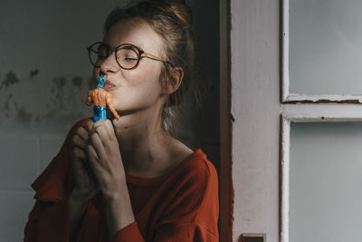 Young woman kissing superhero comic figurine