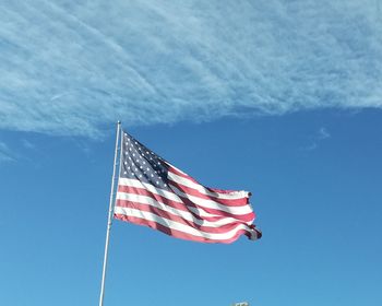 Low angle view of flag against blue sky