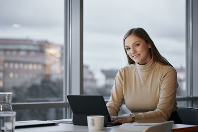 Portrait of businesswoman using tablet in office