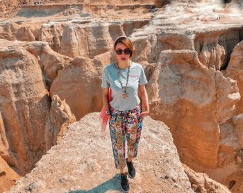 Portrait of woman standing against rock formations