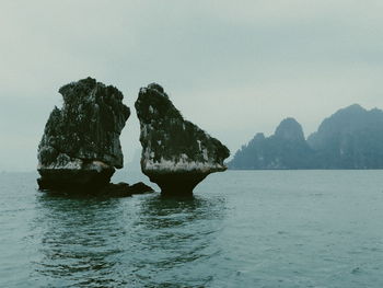 Scenic view of rock formation in sea against clear sky