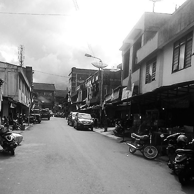 transportation, land vehicle, building exterior, architecture, mode of transport, car, built structure, street, parked, parking, bicycle, city, stationary, the way forward, road, sky, diminishing perspective, residential structure, residential building, vanishing point