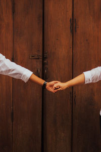 Midsection of people on wooden door