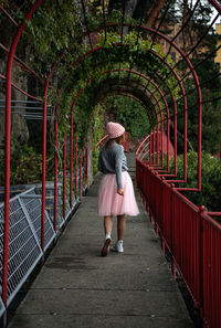 Rear view of woman walking on footbridge