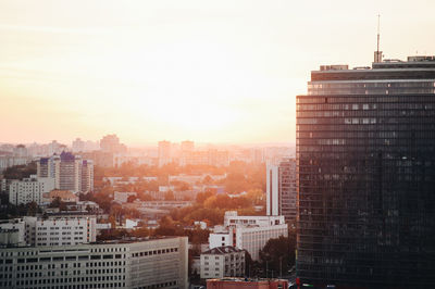 Buildings in city against sky during sunset